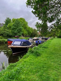 Beautiful view of green lawn near canal with different boats