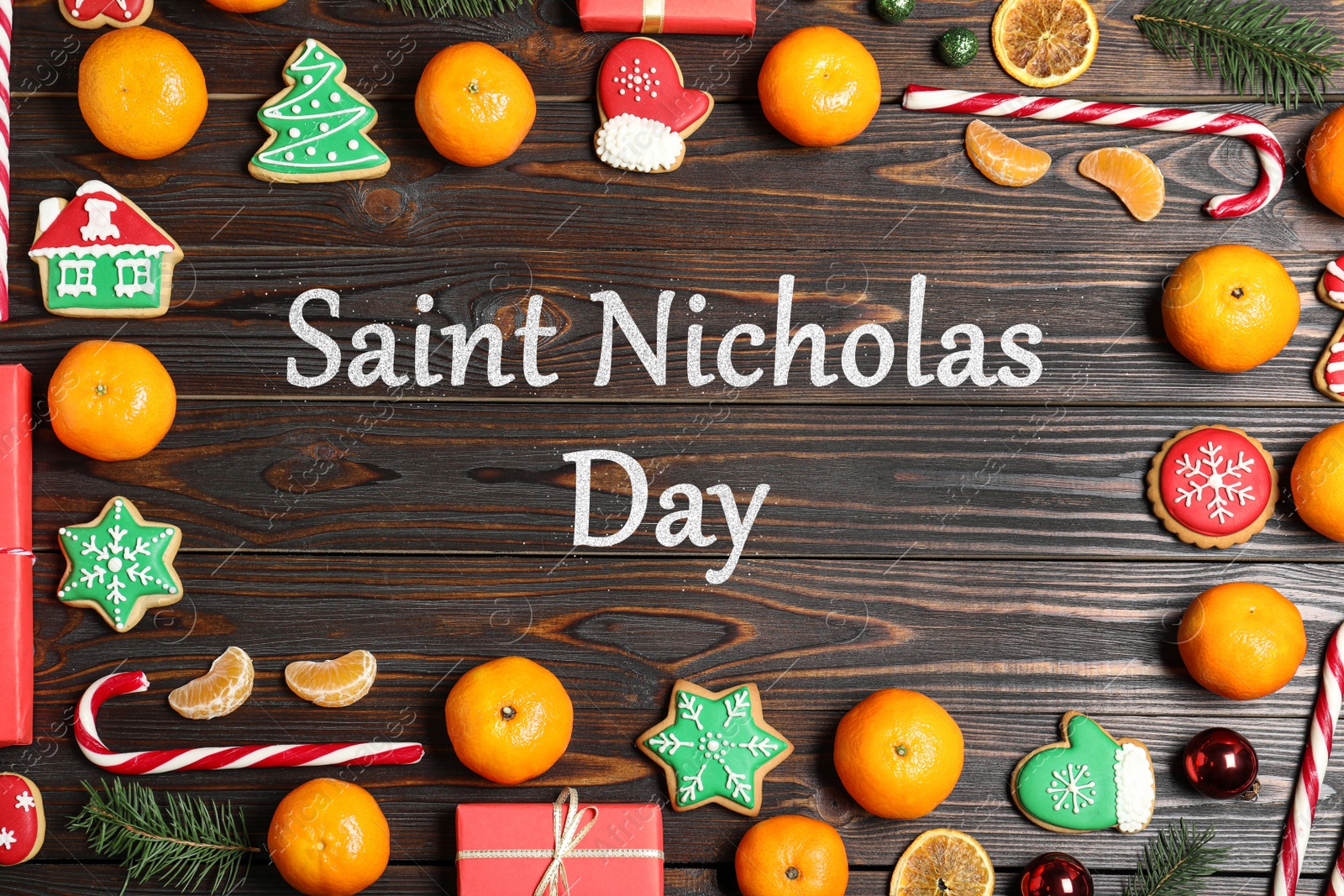 Image of Saint Nicholas Day. Frame made with tasty Christmas cookies and tangerines on wooden background, flat lay