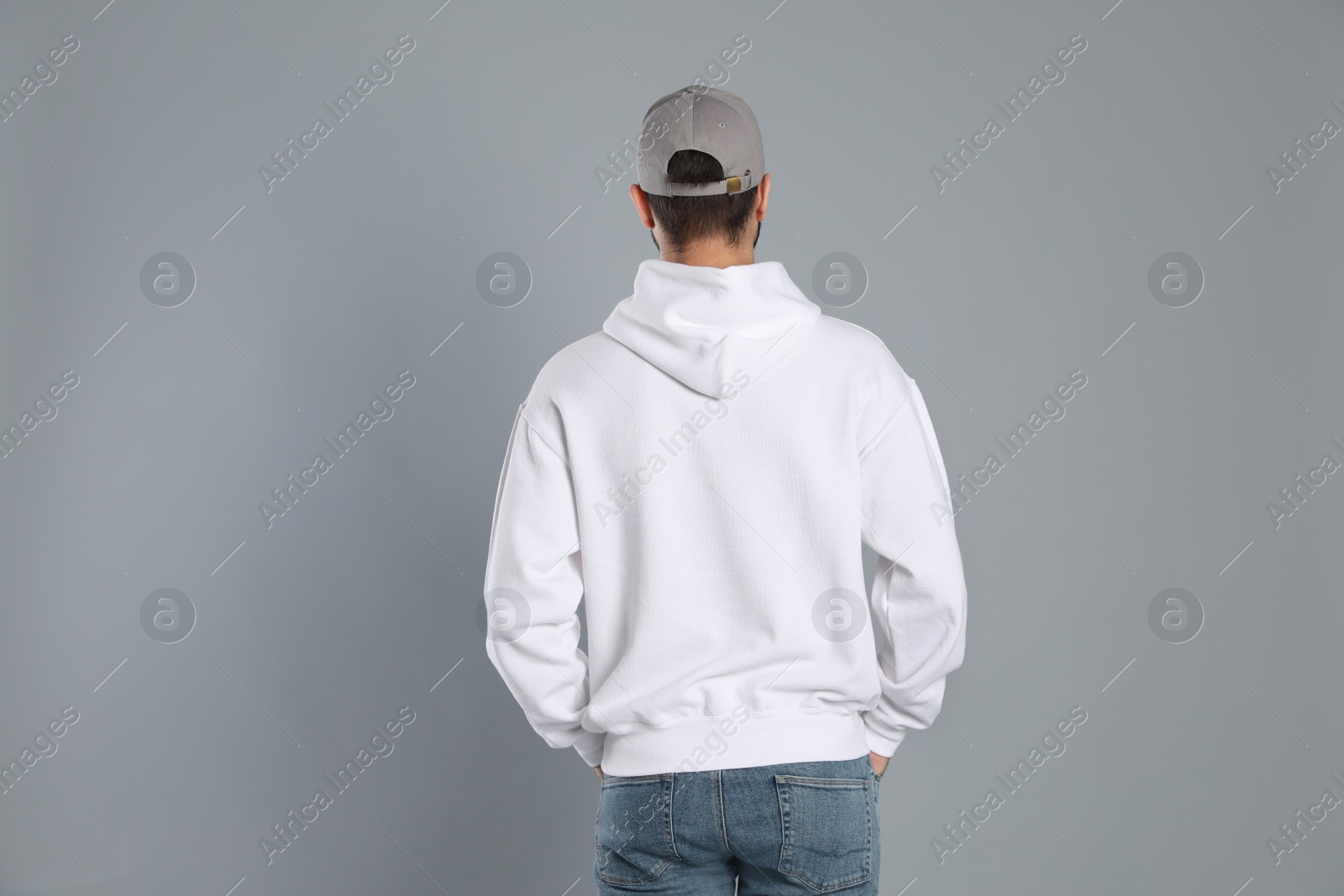 Photo of Young man in sweater on grey background. Mock up for design