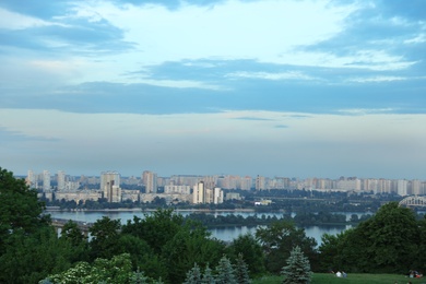 Photo of KYIV, UKRAINE - MAY 23, 2019: Beautiful cityscape with green park and Darnitsky railway bridge