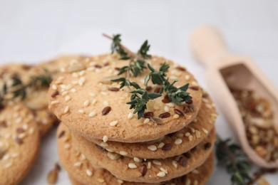 Photo of Stack of cereal crackers with flax, sesame seeds and thyme on blurred background, closeup
