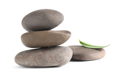 Spa stones with green leaf isolated on white