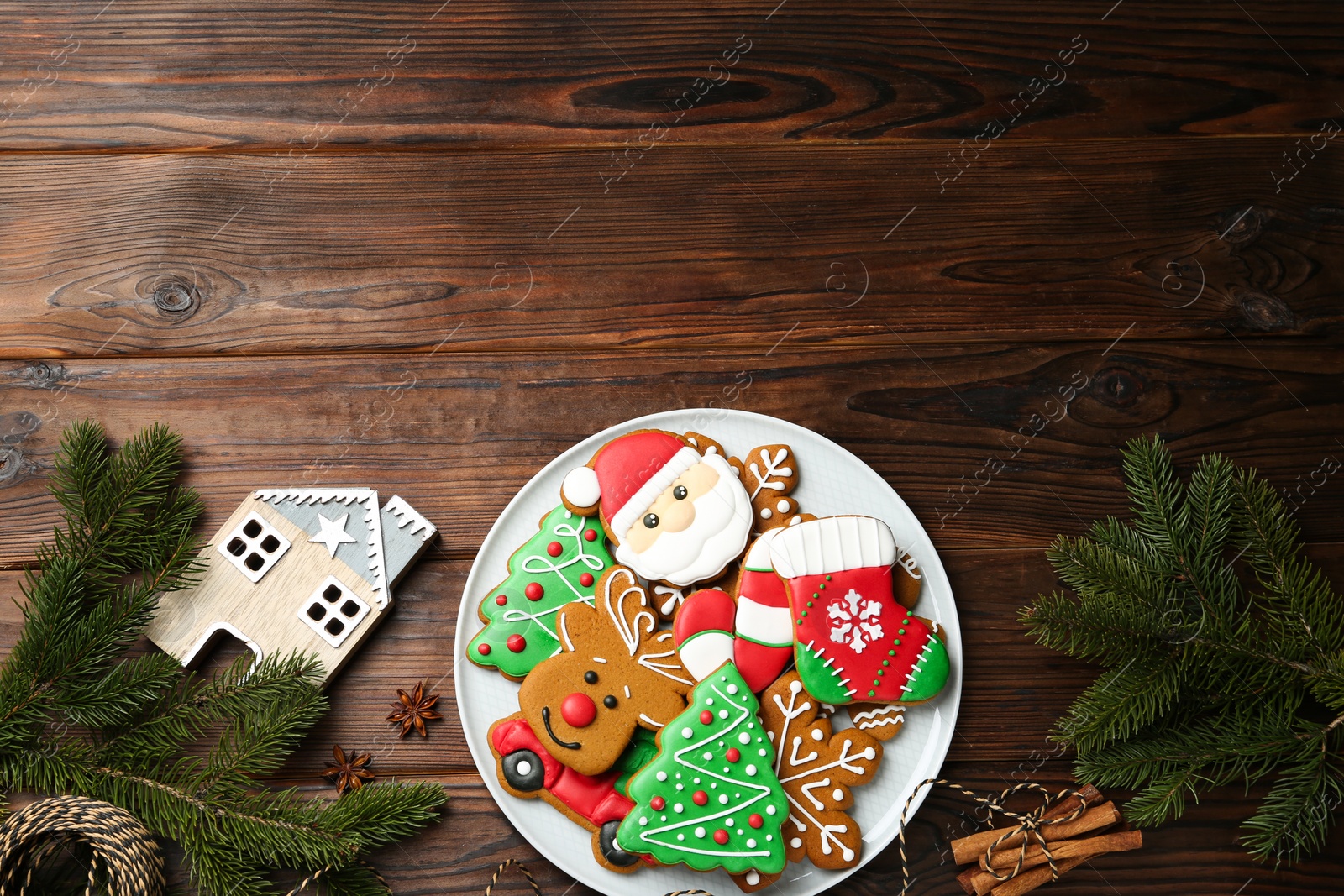 Photo of Different tasty Christmas cookies and festive decor on wooden table, flat lay. Space for text