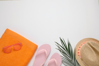 Photo of Beach towel, flip flops , sunglasses and hat on white background, flat lay. Space for text