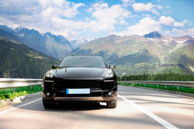 Image of Modern car on asphalt road in mountains