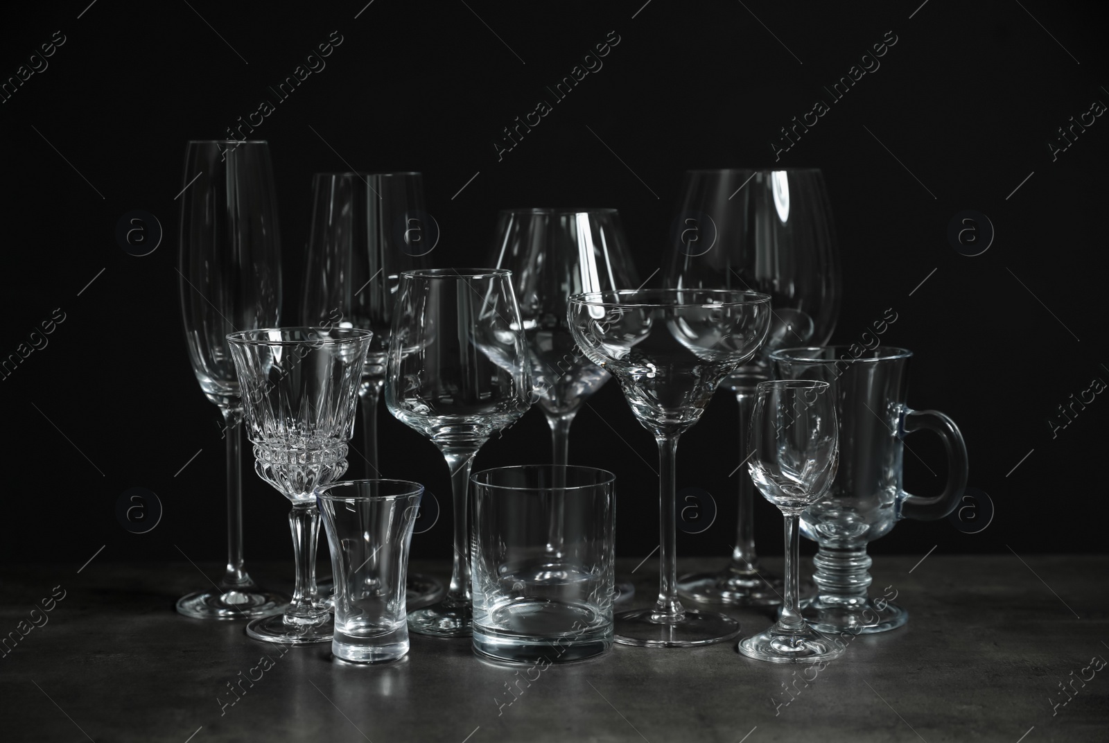 Photo of Set of bar glassware on table against dark background