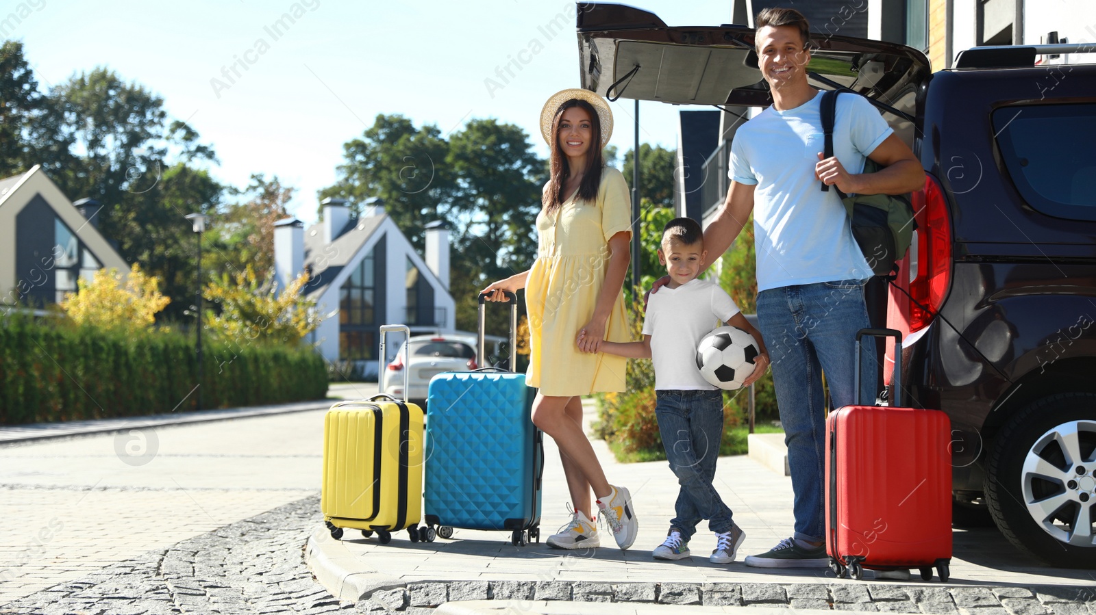 Photo of Happy family with suitcases near car outdoors. Moving day