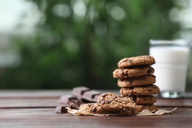 Photo of Delicious chocolate chip cookies on wooden table, space for text