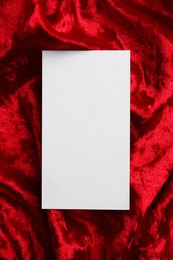 Photo of Blank business card on red fabric, top view. Mockup for design