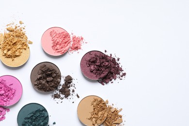 Photo of Different crushed eye shadows on white background, flat lay. Space for text