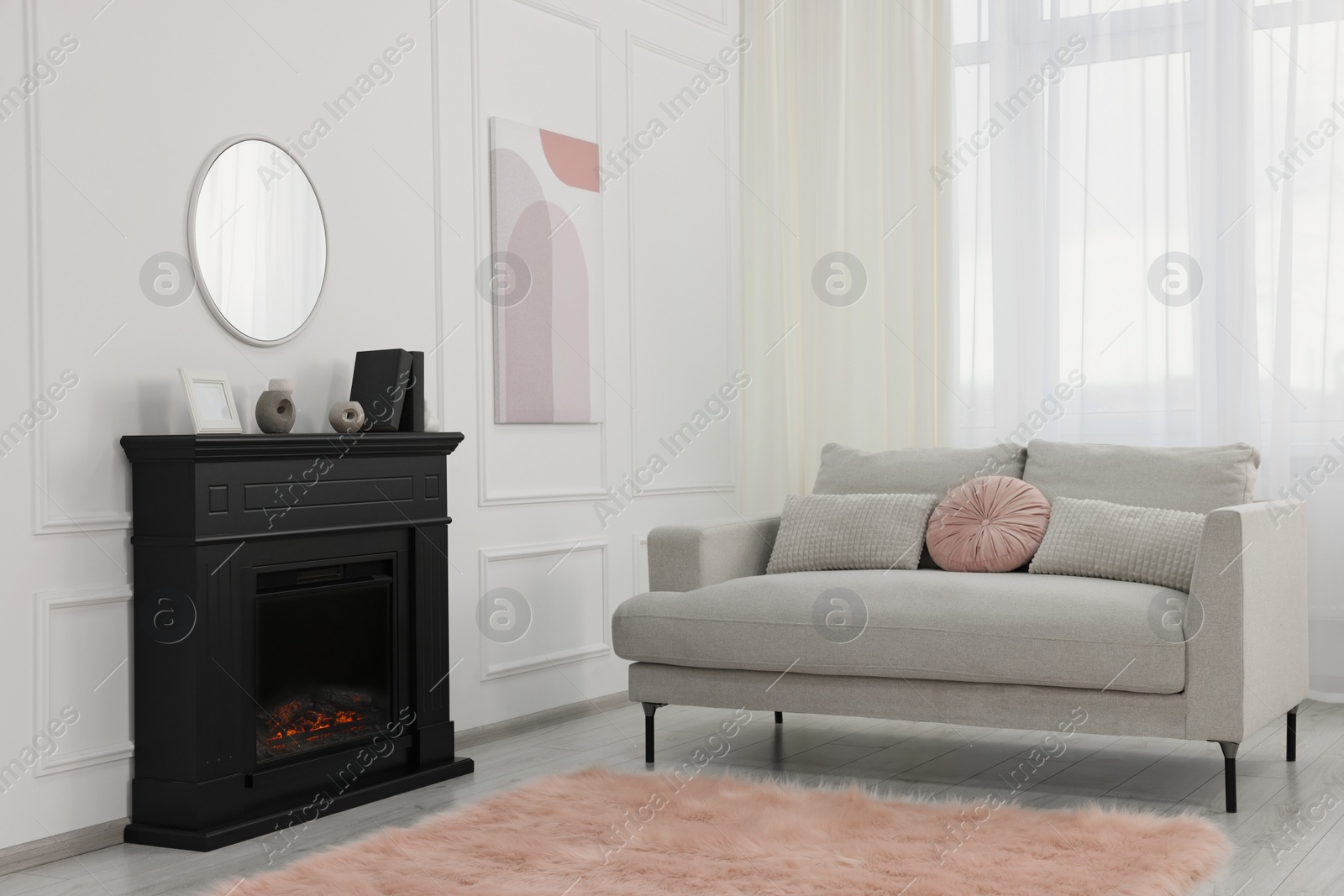 Photo of Black stylish fireplace near comfortable sofa in cosy living room