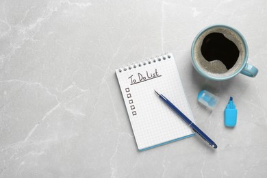 Photo of Notepad with unfilled To Do list, pen, marker and cup of coffee on grey marble table, flat lay. Space for text