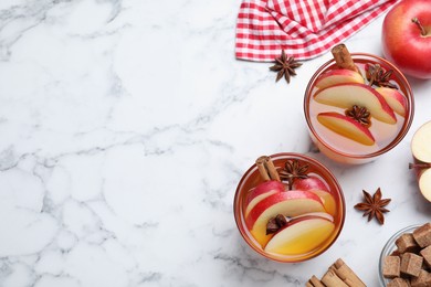Photo of Aromatic hot mulled cider on white marble table, flat lay. Space for text