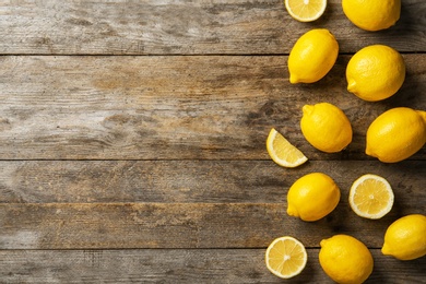 Photo of Flat lay composition with whole and sliced lemons on wooden background