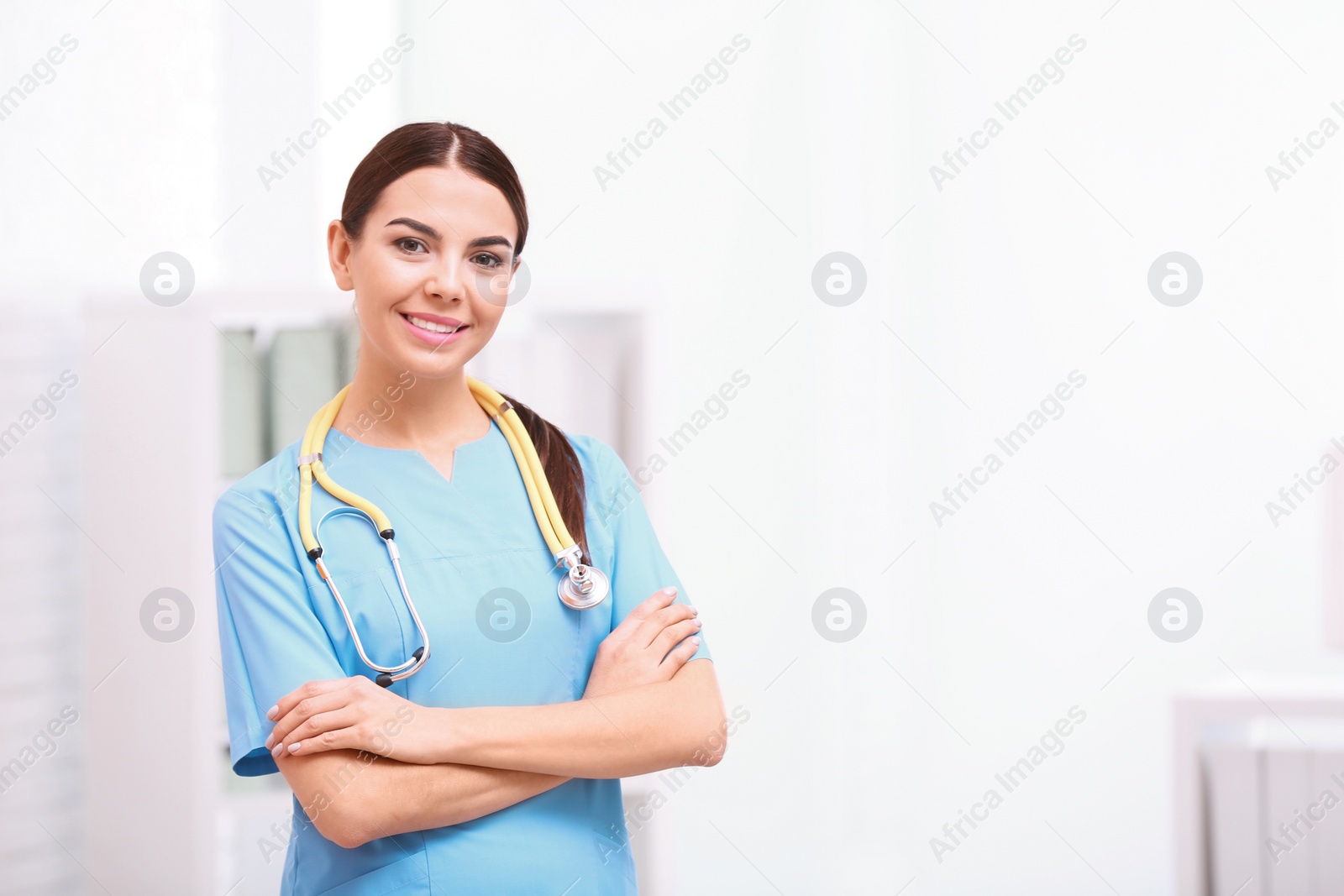 Photo of Portrait of medical assistant with stethoscope in hospital. Space for text