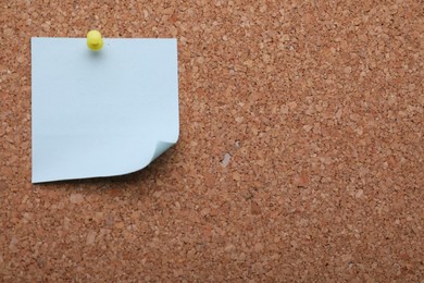 Photo of Blank paper note pinned to cork background, closeup. Space for text
