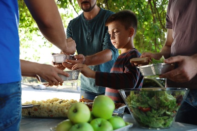 Photo of Poor people receiving food from volunteer outdoors