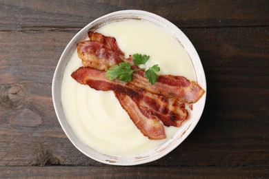 Photo of Delicious potato soup with bacon and parsley on wooden table, top view