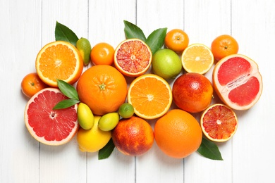 Flat lay composition with different citrus fruits on white wooden background