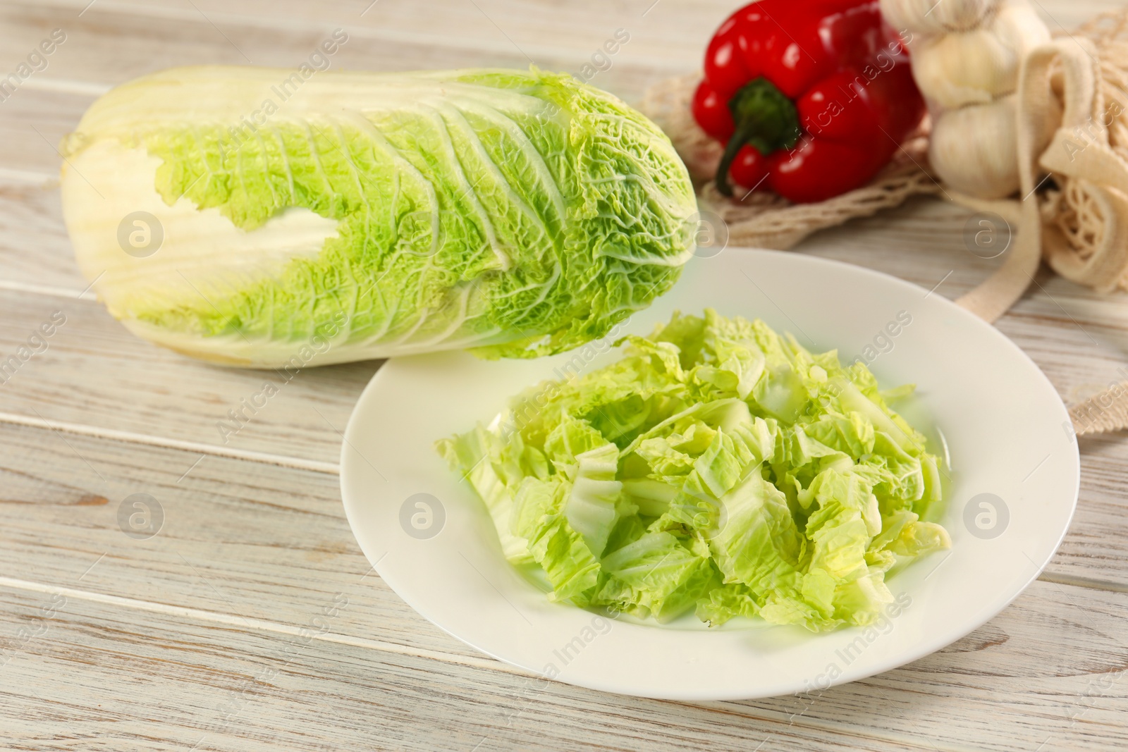 Photo of Fresh Chinese cabbage, bell pepper and garlic on wooden table