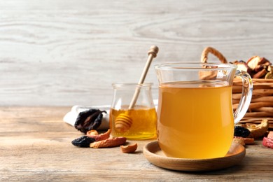 Delicious compote in glass cup on wooden table, space for text