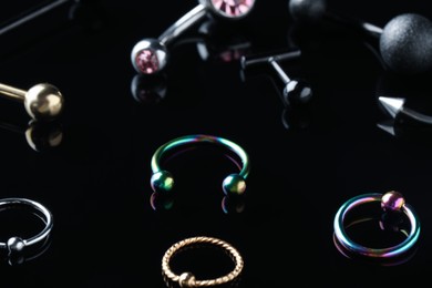 Photo of Stylish jewelry for piercing on black background