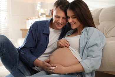 Young pregnant woman with her husband at home