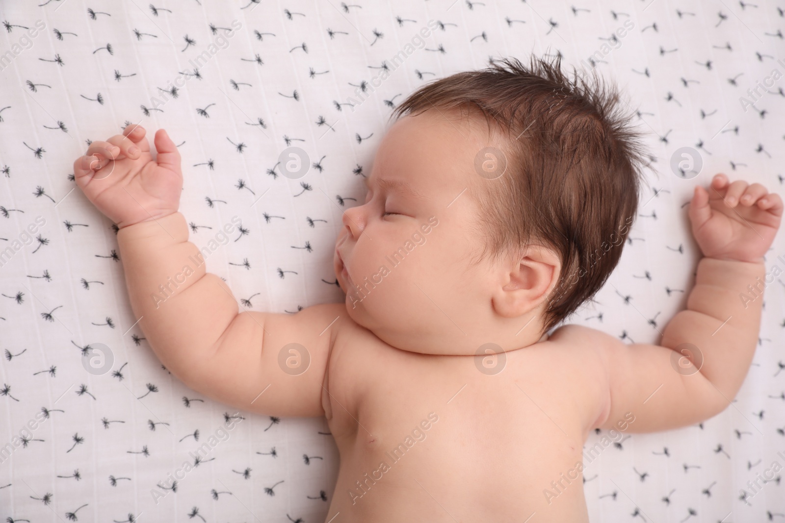 Photo of Cute little baby sleeping in crib at home, top view. Bedtime