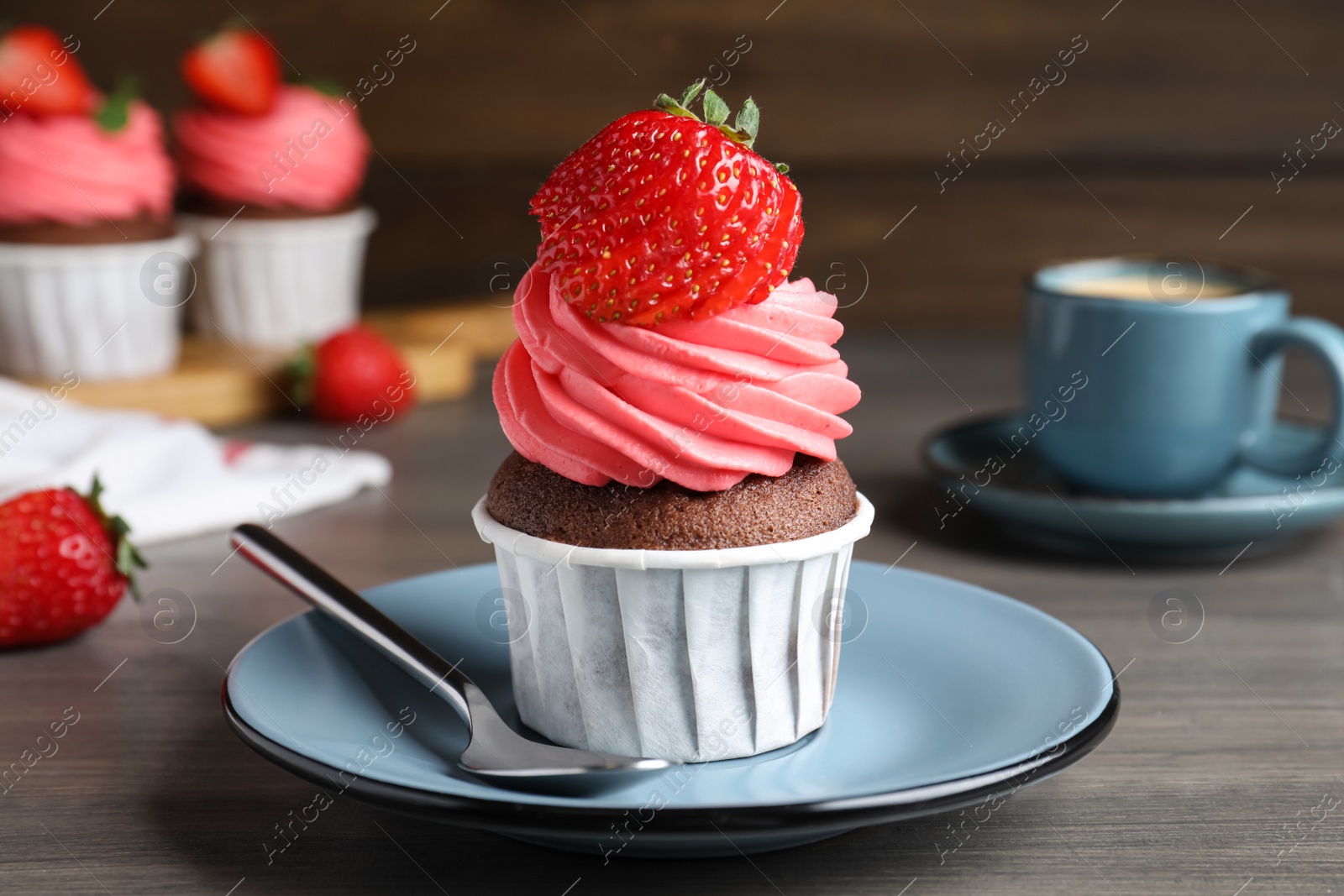 Photo of Sweet cupcake with fresh strawberry on wooden table