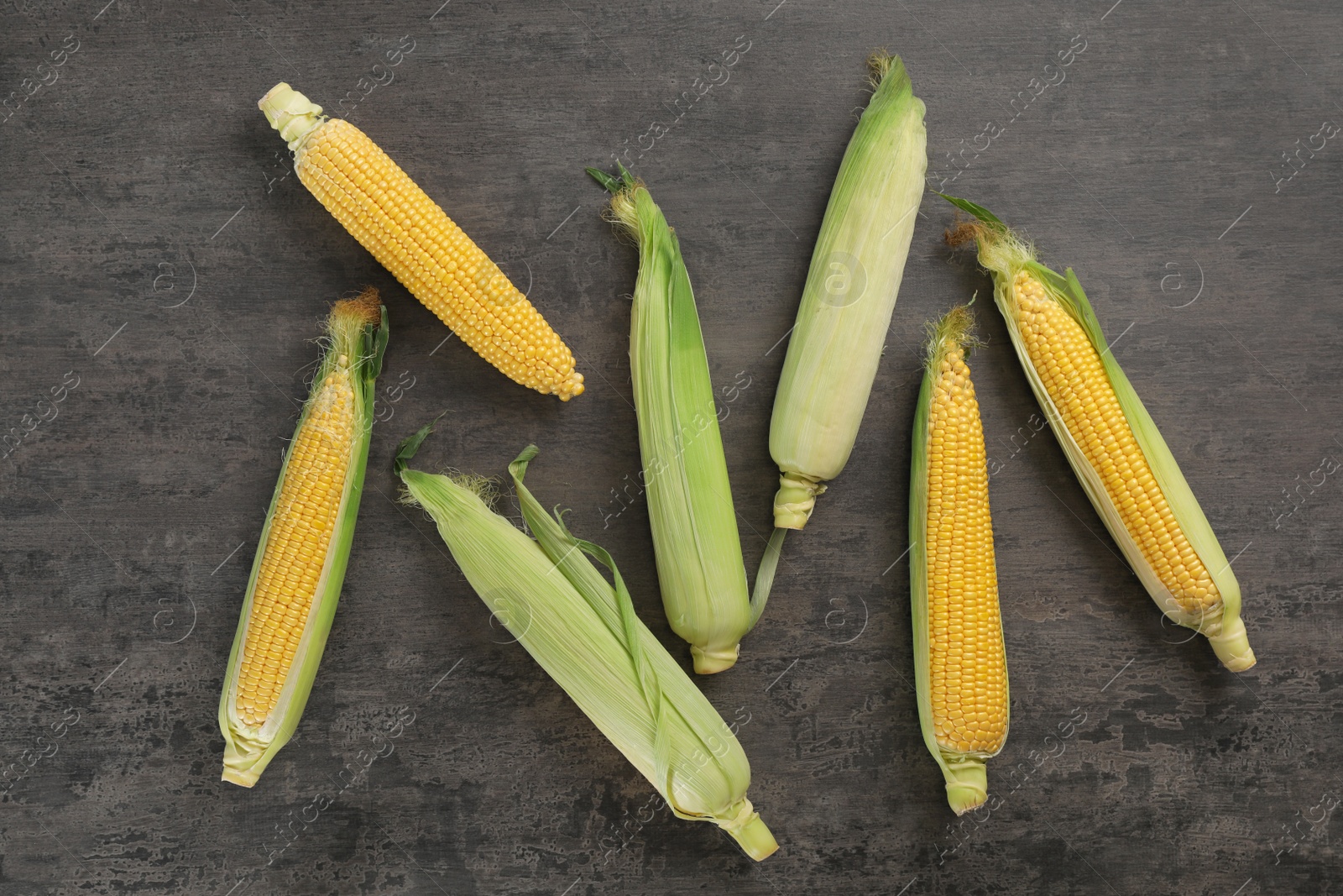 Photo of Tasty sweet corn cobs on table, top view