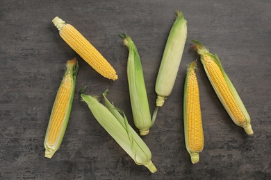 Tasty sweet corn cobs on table, top view