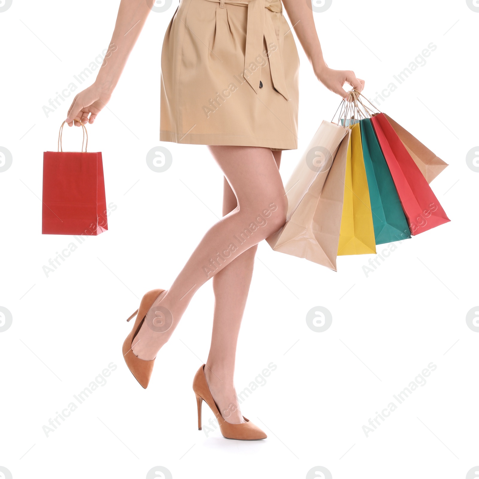 Photo of Young woman with shopping bags on white background, closeup of legs