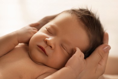 Woman holding her sleeping newborn baby, closeup
