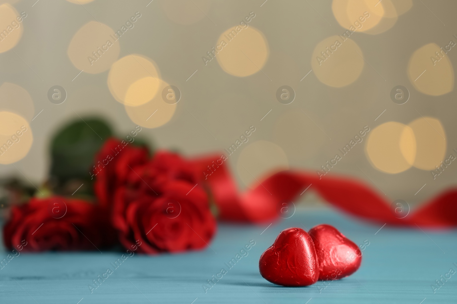 Photo of Heart shaped chocolate candies on light blue table, space for text. Valentines's day celebration