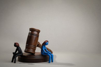 Photo of Divorce concept. Plasticine people figures and wooden gavel on light grey background, space for text