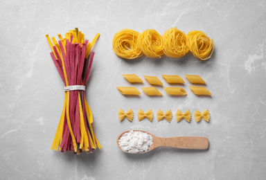 Flat lay composition with different types of pasta on light grey table