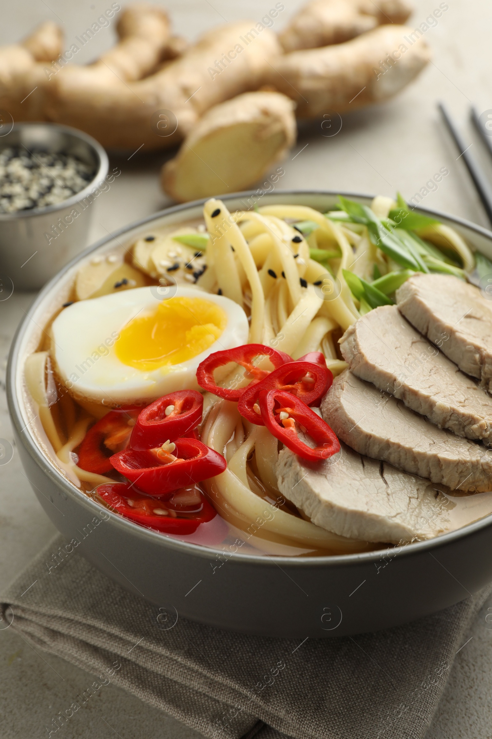 Photo of Delicious ramen in bowl on light table, closeup. Noodle soup