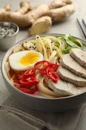 Photo of Delicious ramen in bowl on light table, closeup. Noodle soup