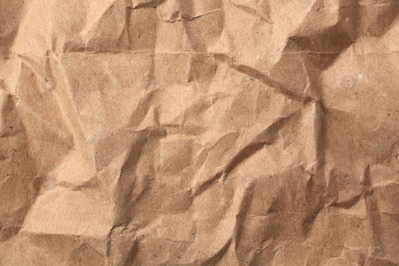 Photo of Sheet of crumpled kraft paper as background, top view