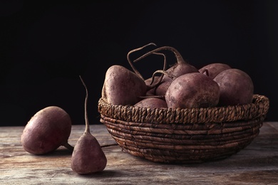 Basket with whole fresh beets on wooden table