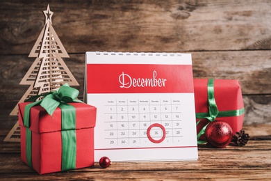 Photo of Calendar with marked Boxing Day date near gifts and decorative Christmas tree on wooden table