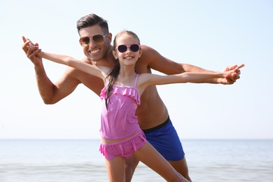 Photo of Father playing with daughter at beach. Family vacation