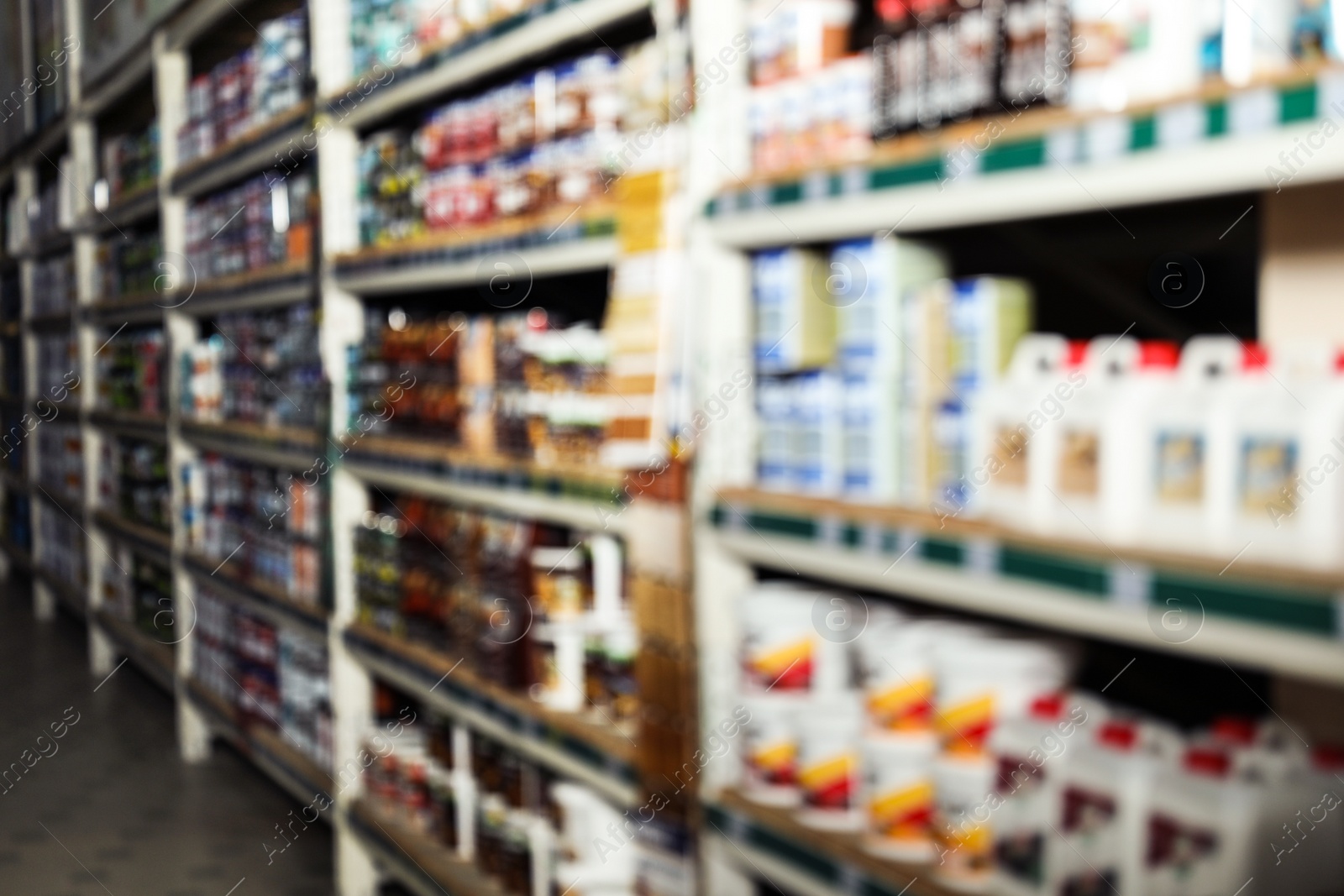 Photo of Blurred view of storage stands with different building materials in wholesale warehouse