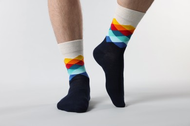 Man in stylish colorful socks on white background, closeup