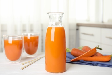 Photo of Freshly made carrot juice on white table