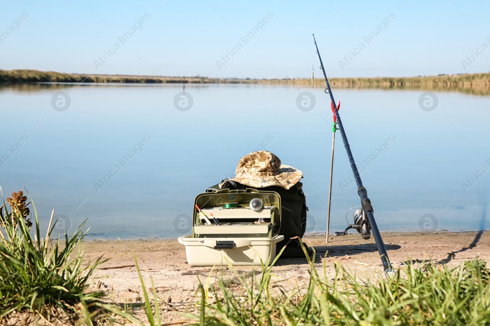 Photo of Rod and fishing essentials at riverside on sunny day