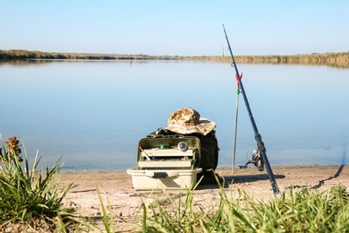 Rod and fishing essentials at riverside on sunny day