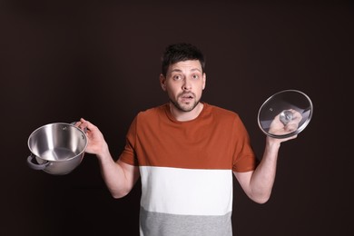 Upset man with empty pot on dark background