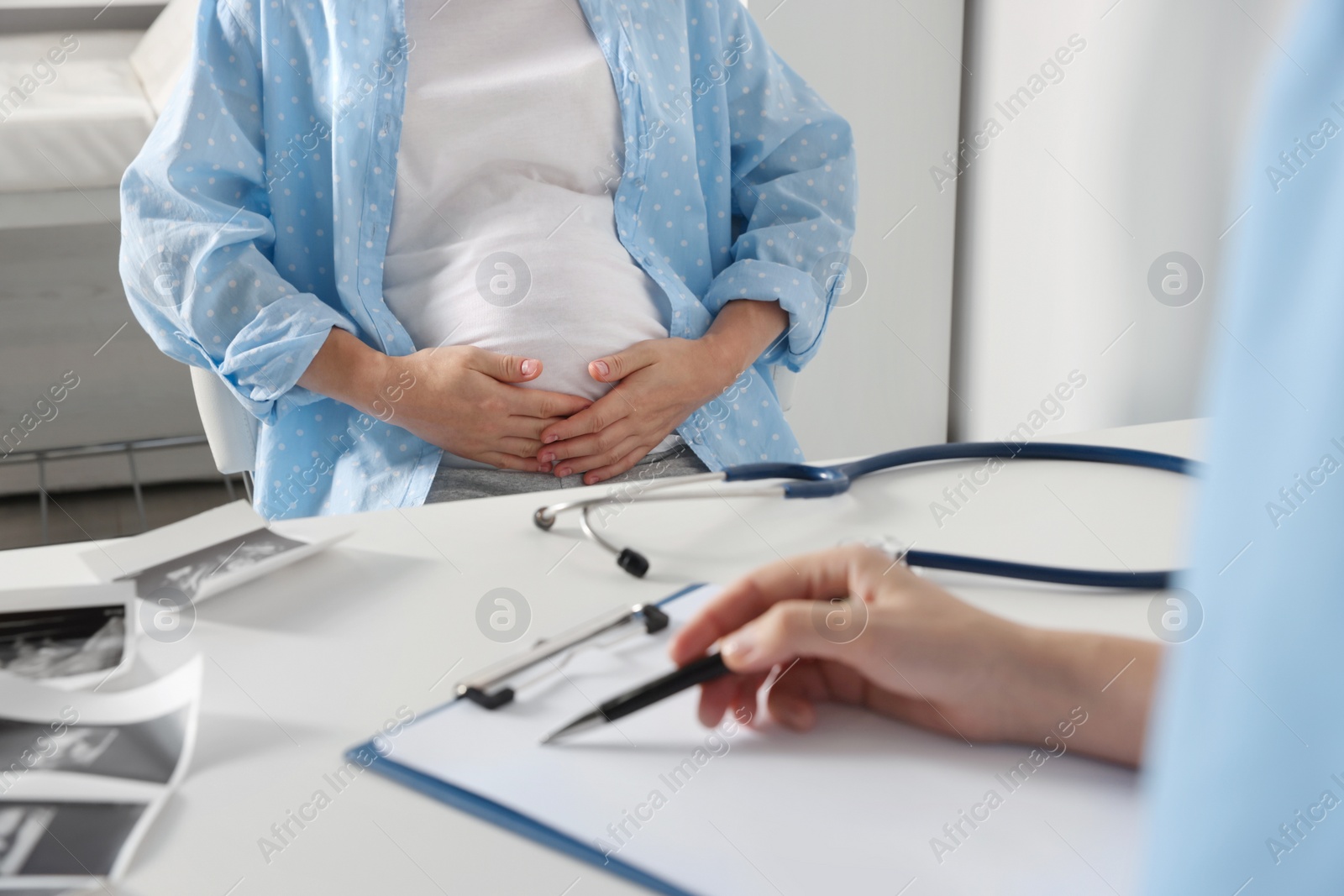 Photo of Pregnant woman having doctor appointment in hospital, closeup