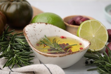 Tasty fish marinade with rosemary and products on light table, closeup